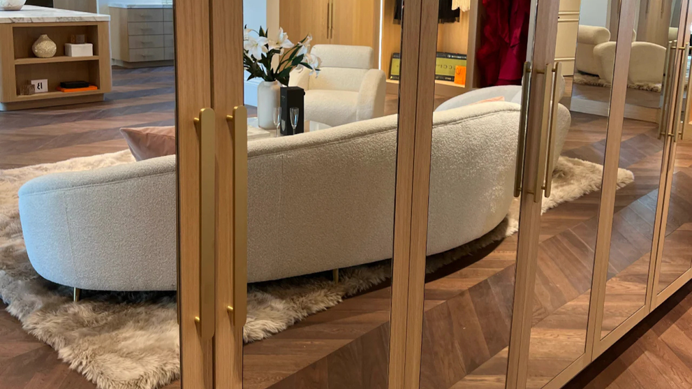 Orbital, solid brass cabinet pulls paired with floor-to-ceiling glass doors