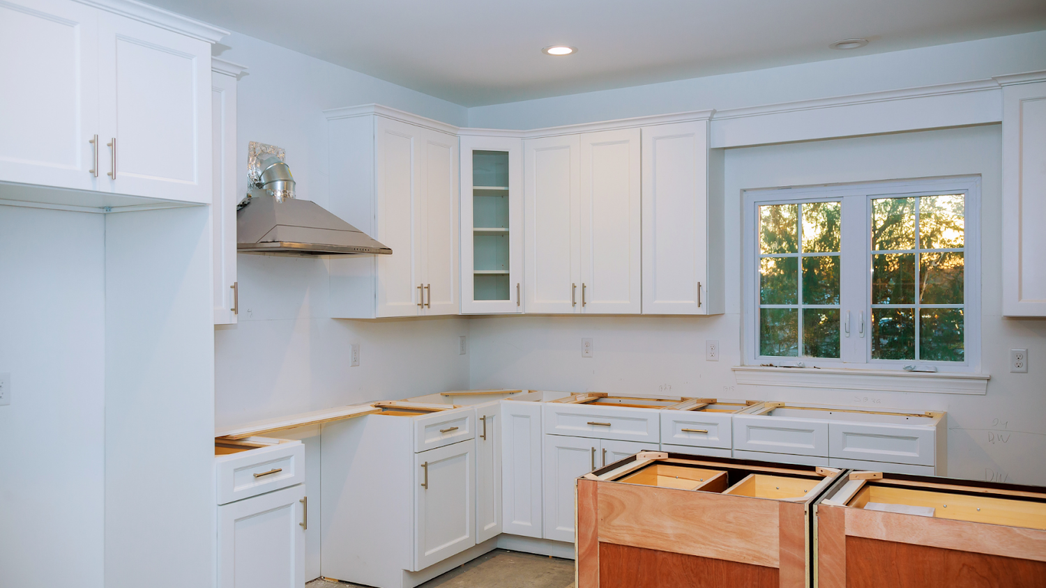White Shaker-Style Kitchen Cabinets Featuring Brushed Brass Pulls And Knobs