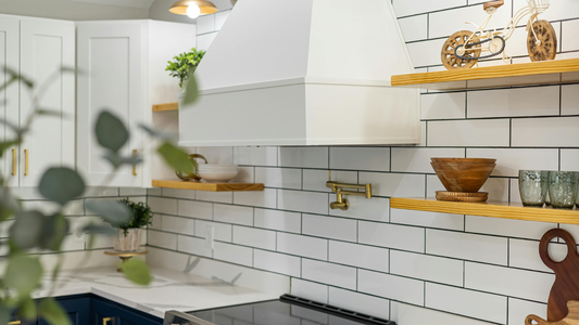 White minimalist kitchen with brass appliances and wooden open shelves