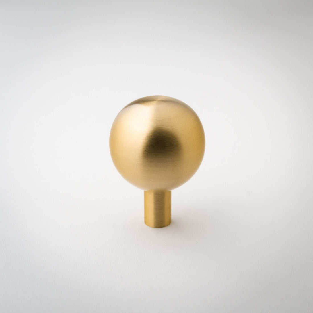 Dumas ball knob with a brushed brass surface