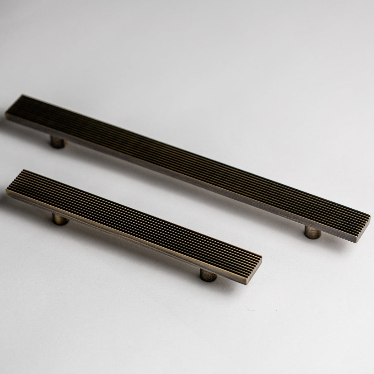 Rail cabinet pulls in Antique Brass