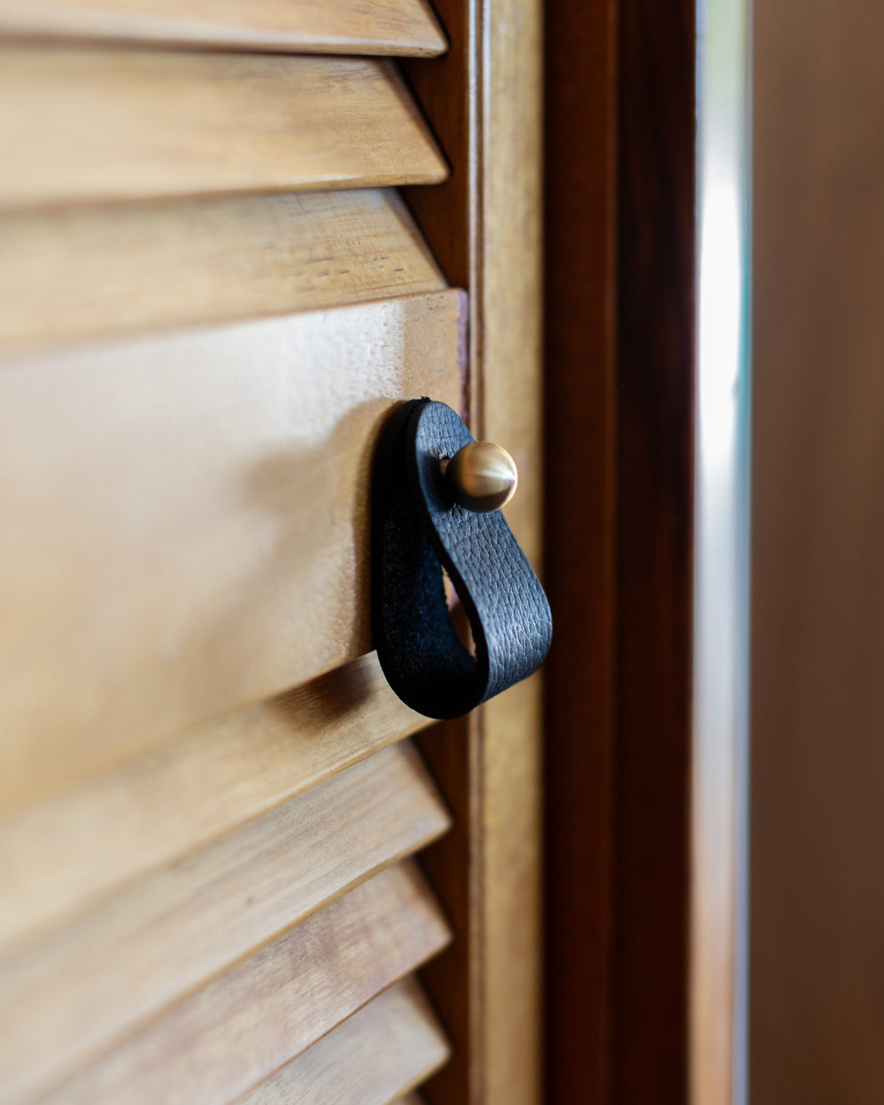 Ball Leather Pull in Ebony on a wooden louvered door