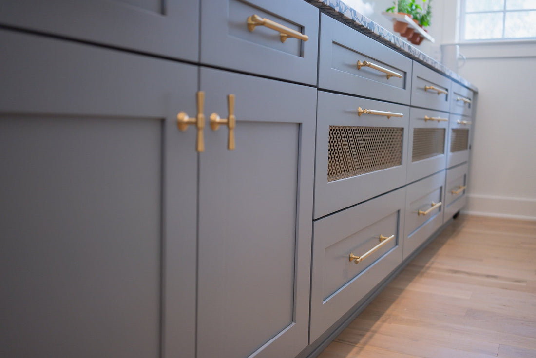 Tuxedo knobs and pulls aligned on blue-gray pantry cabinet doors and drawers