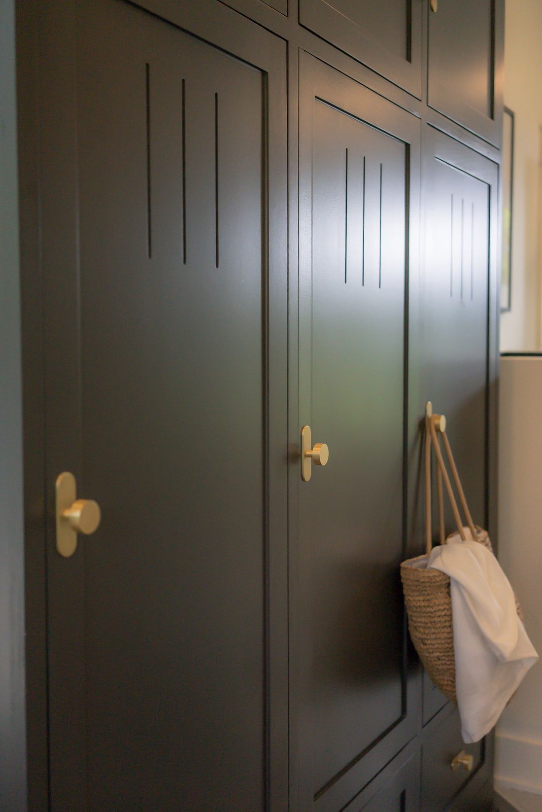 Dark blue built-in storage with repeated Orbital cabinet knobs