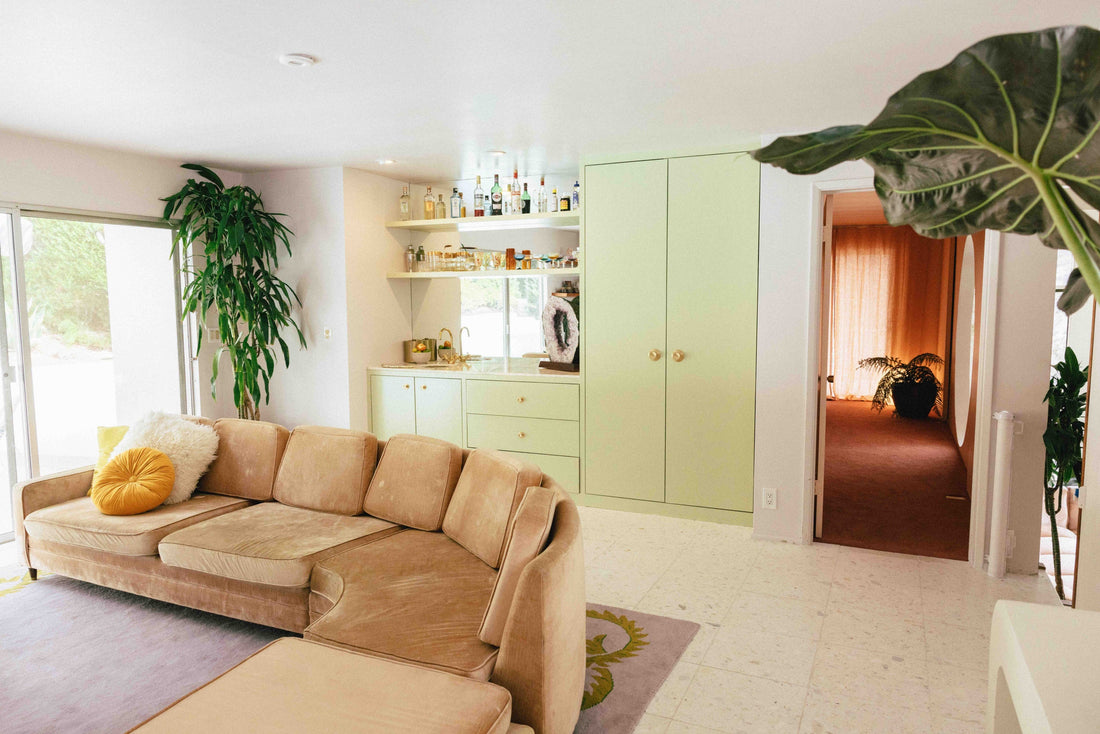 Living room with pale green built-ins and Sunburst brass cabinet knobs
