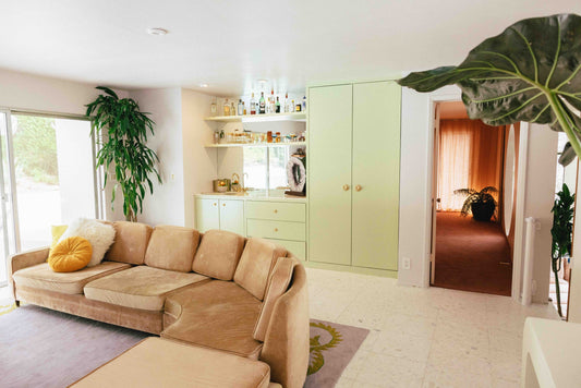 Living room with pale green built-ins and Sunburst brass cabinet knobs