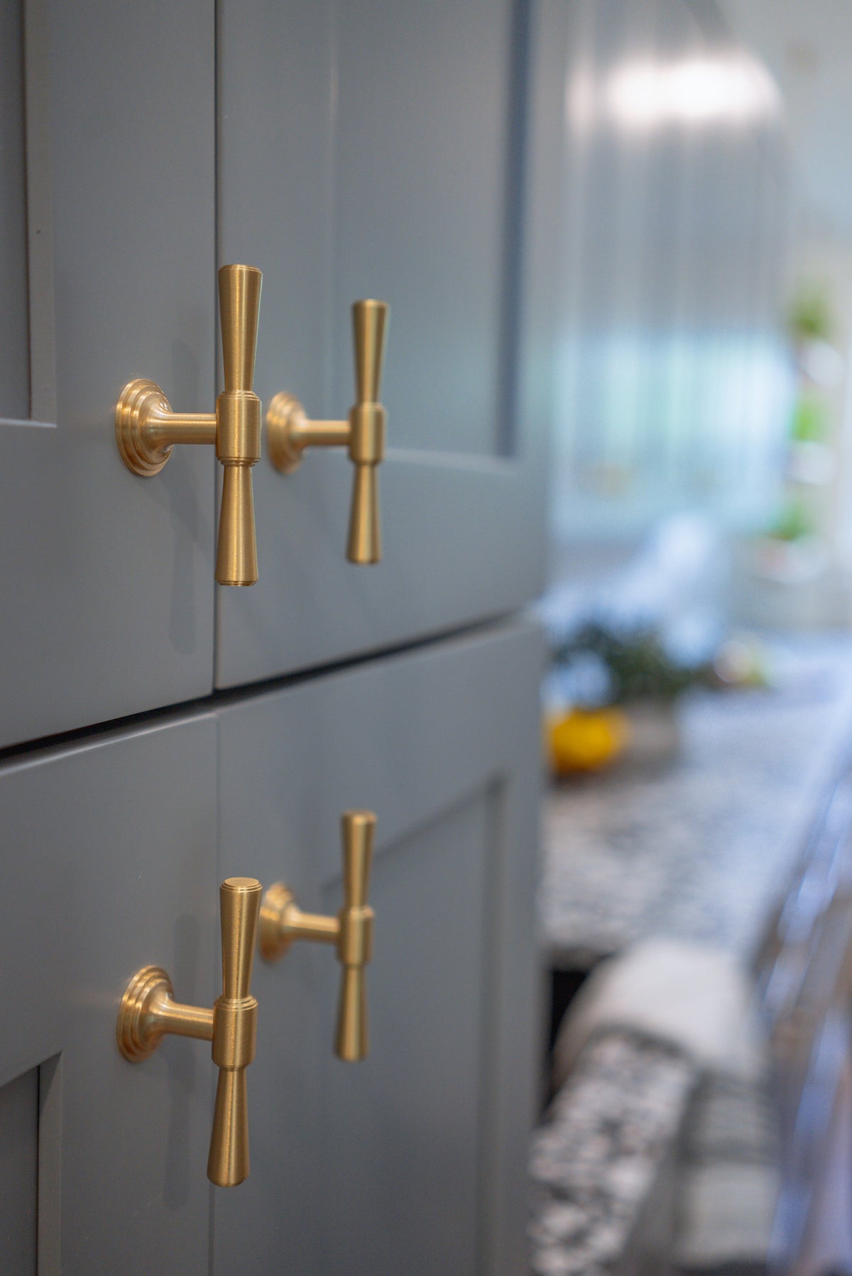 Tuxedo knobs on aligned blue-gray framed cabinet doors