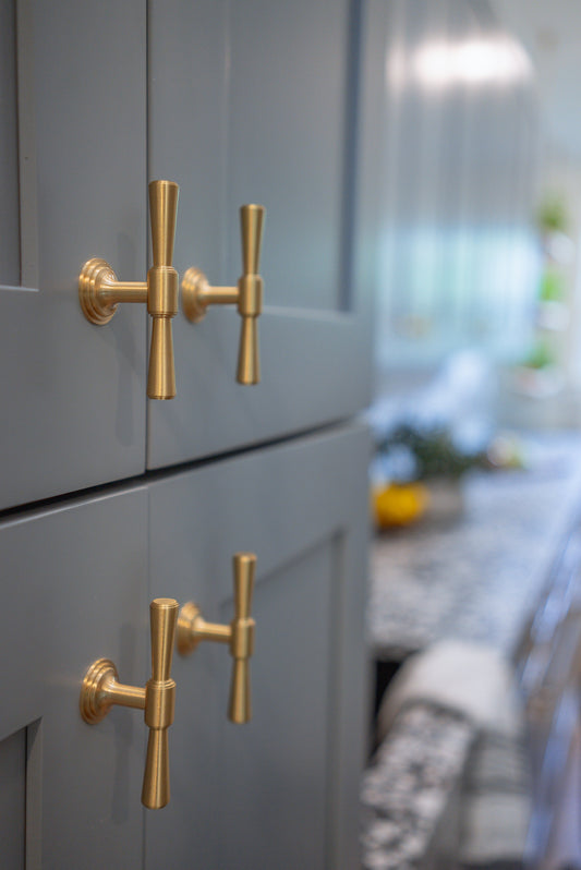 Tuxedo knobs on aligned blue-gray framed cabinet doors