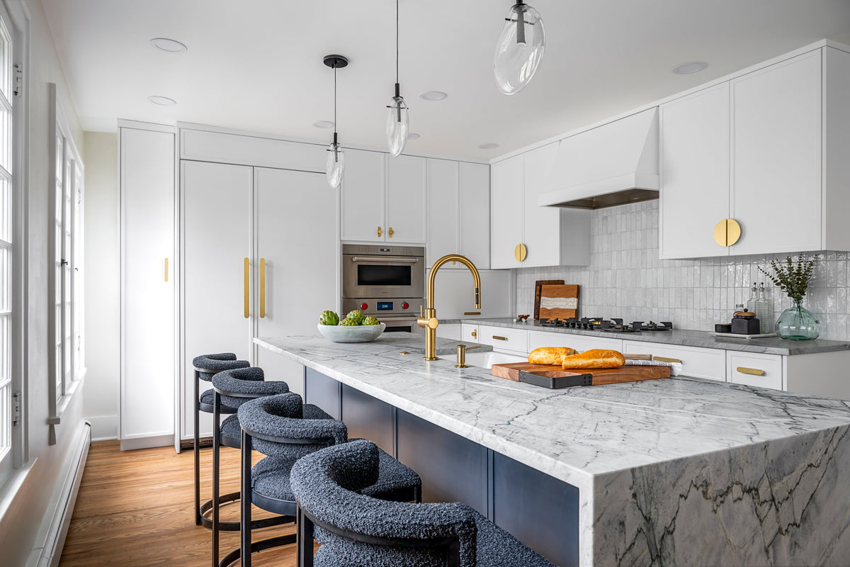 Modern white kitchen with a dark island and brass cabinet hardware