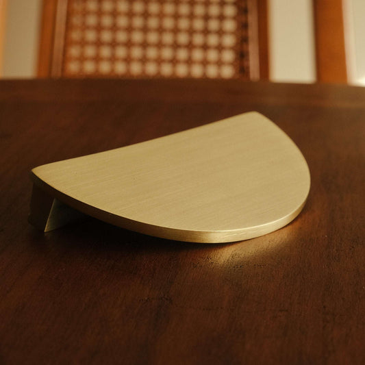 Demi Lune cabinet pull on a wooden surface
