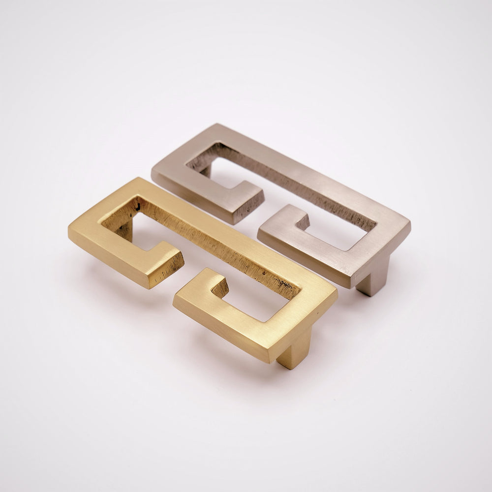 Two open rectangular cabinet pulls in contrasting finishes